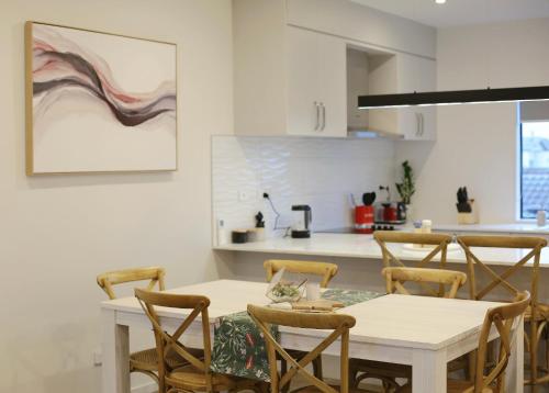 a kitchen and dining room with a table and chairs at Cozy and comfortable, sunny three-storey building in Auckland