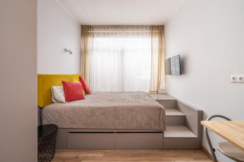 ein kleines Schlafzimmer mit einem Bett und einem Fenster in der Unterkunft Dzintaru studio in Jūrmala