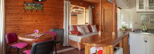 eine Küche mit einem Tisch und ein Zimmer mit einem Bett in der Unterkunft Cabaña Le Betulle in San Martín de los Andes