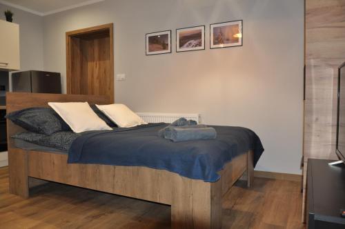 ein Schlafzimmer mit einem Holzbett mit zwei Kissen in der Unterkunft Apartamenty Sudety in Bystrzyca Kłodzka
