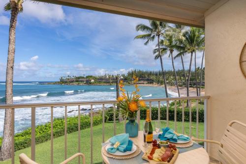 a table on a balcony with a view of the ocean at Napili Shores A202 OF Studio condo in Kahana