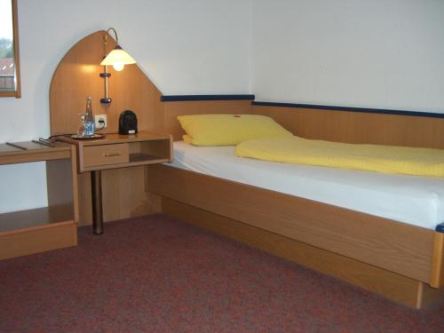 a bedroom with a bed and a desk with a lamp at Zur Alten Post in Nottuln