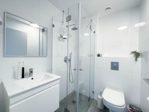 uma casa de banho com um chuveiro, um WC e um lavatório. em Midtown Tel Aviv Luxury Apartment em Tel Aviv