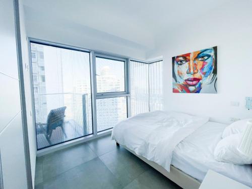 ein Schlafzimmer mit einem Bett und einem großen Fenster in der Unterkunft Midtown Tel Aviv Luxury Apartment in Tel Aviv