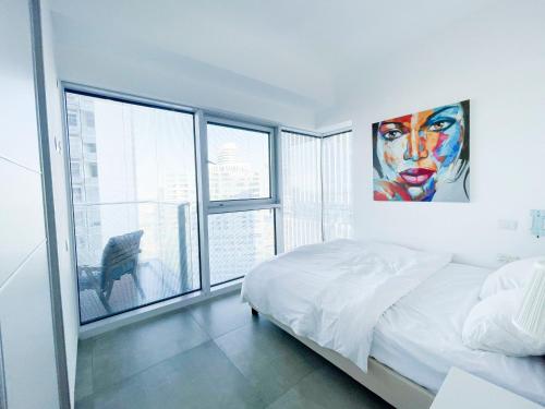 a bedroom with a bed and a large window at Midtown Tel Aviv Luxury Apartment in Tel Aviv