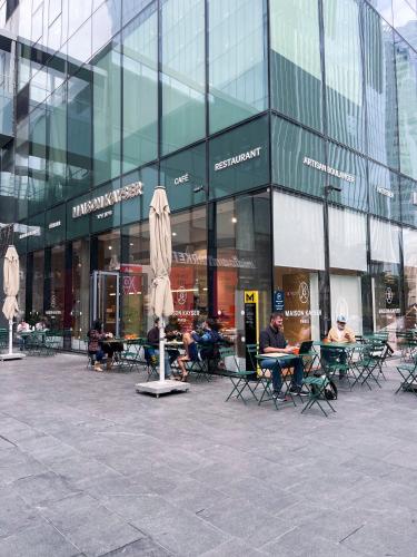 a group of people sitting in chairs in front of a building at Midtown Tel Aviv Luxury Apartment in Tel Aviv
