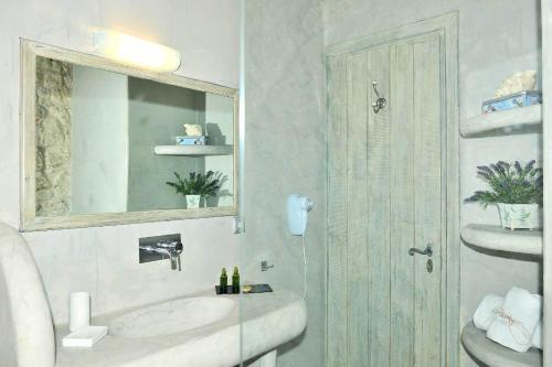 a bathroom with a sink and a mirror and a shower at Mounty Island Villas in Lazaráta