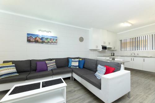 a living room with a couch and a kitchen at Forster Lodge 8 in Forster