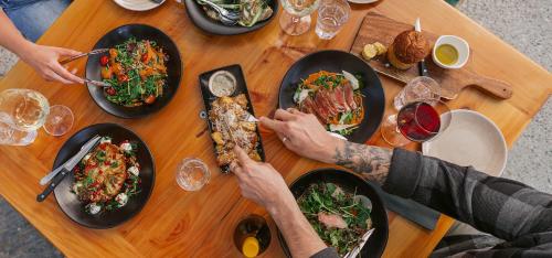 a group of people sitting at a table with plates of food at Cottages at Kinross in Gibbston