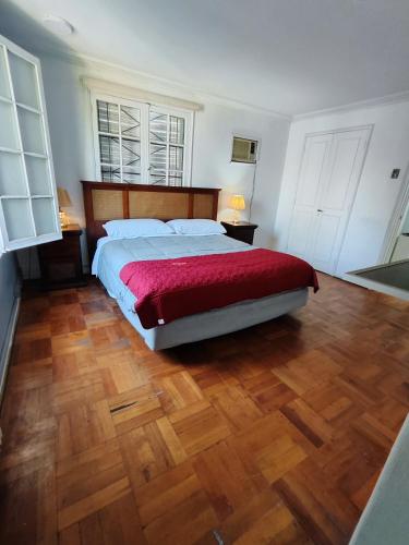 a bedroom with a large bed and wooden floors at HOSTAL SUZI in Santiago