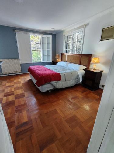 a bedroom with a large bed and a wooden floor at HOSTAL SUZI in Santiago