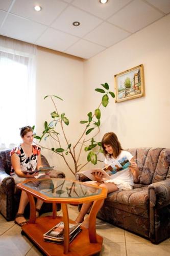 a group of three people sitting on a couch at Hárs Thermál Hotel in Gyomaendrőd