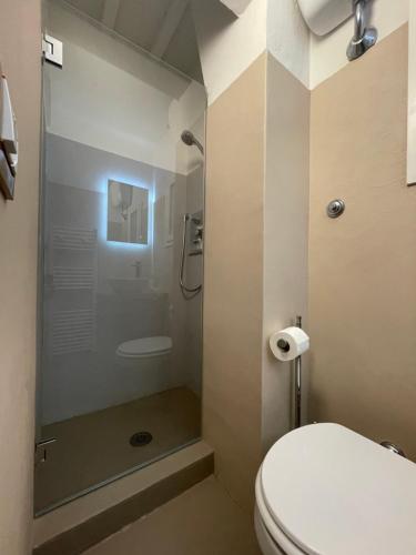 a bathroom with a toilet and a glass shower at Rjgal Apartment B&B in Florence