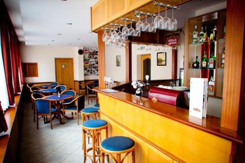 a bar with blue stools in a restaurant at Hárs Thermál Hotel in Gyomaendrőd