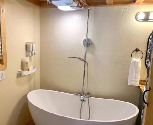 a bath tub in a bathroom with a shower at Sunshine Tiny Home Near Downtown SLO in San Luis Obispo