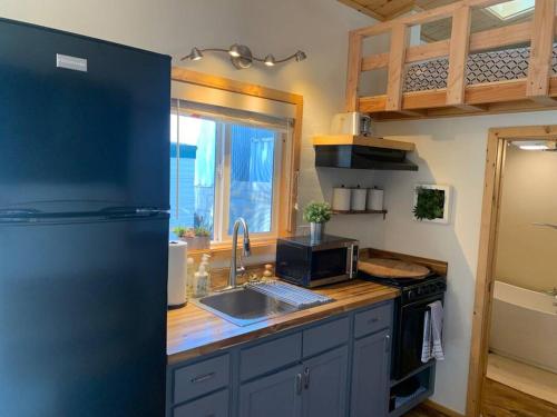 a kitchen with a refrigerator and a sink and a stove at Sunshine Tiny Studio and Loft Close to Downtown in San Luis Obispo