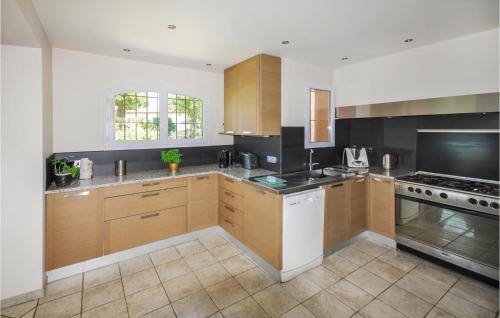 une cuisine avec des armoires en bois et un four à plaques de cuisson dans l'établissement Nice Home In Roquefort Les Pins, à Roquefort-les-Pins