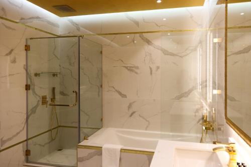 a bathroom with a shower and a tub and a sink at The B Premiere Hotel in Doha