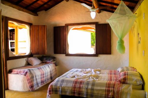 um quarto com uma cama, um sofá e uma janela em Pousada Cavallitos d'Amar na Ilha de Boipeba