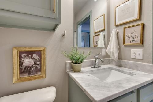 a white bathroom with a sink and a mirror at Charming 2 bed 1 bath Tudor - Near Plaza & Midtown in Oklahoma City
