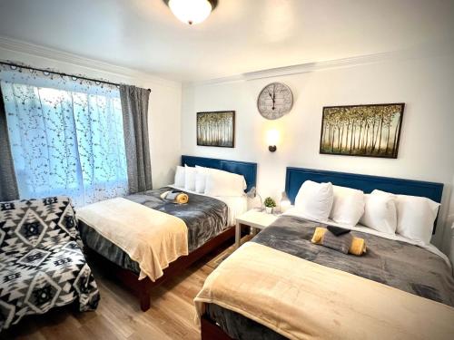 a bedroom with two beds and a clock on the wall at Cobmin Ridge Motel 