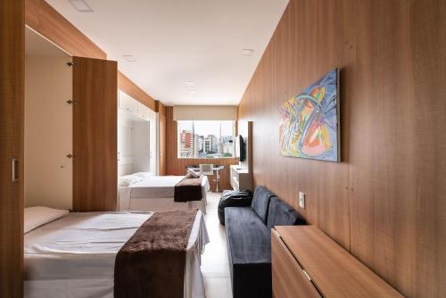 Habitación de hotel con 2 camas y sofá en AÃ - Studio Aconchegante em Higienópolis: Próximo ao Mackenzie e Metrô!, en São Paulo