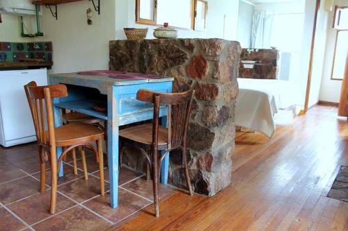 una mesa azul y sillas junto a una pared de piedra en El Observador del Tiempo en San Javier