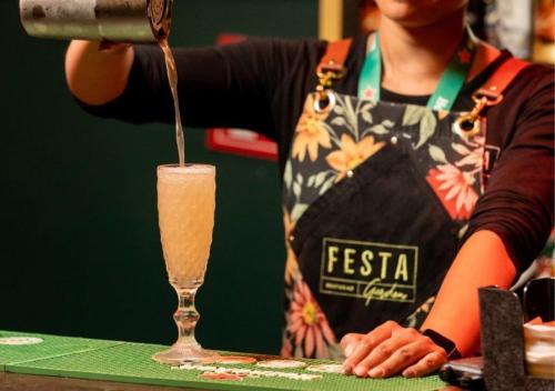 a woman in an apron pouring a drink into a glass at Hotel Casino Talca in Talca