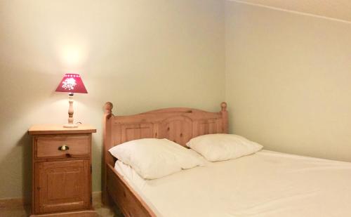 a bedroom with a bed with a lamp on a night stand at ∞ Hyper centre ∞ La marmotte ∞ petit T2 ∞ entrée24h/24 ∞ près ski/cure ≈AX-LES-THERMES≈ wifi ∞ in Ax-les-Thermes