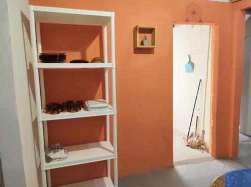 a book shelf in a room with an orange wall at Casa Mar in Baía Formosa