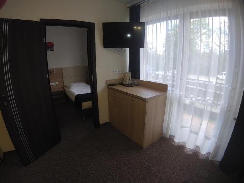 a room with a mirror and a bedroom with a bed at NA BYSTRYM in Zakopane
