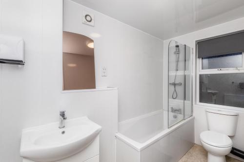 a white bathroom with a sink and a toilet at City Centre Large Luxury Rooms Free Parking in Gateshead