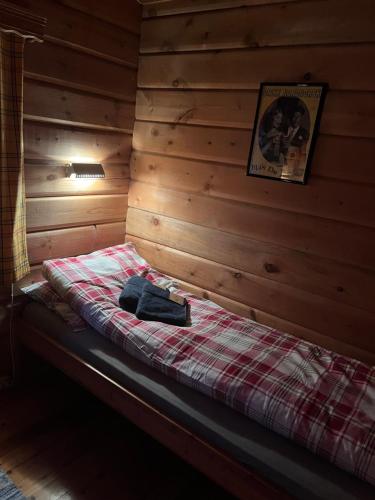 a room with a bed in a log cabin at Macktunet - Retro log cabin from the 70s in Malangen 