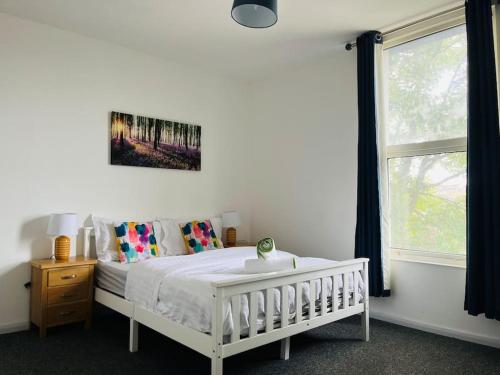 查塔姆的住宿－Chatham hilltop view，卧室配有白色的床和窗户。