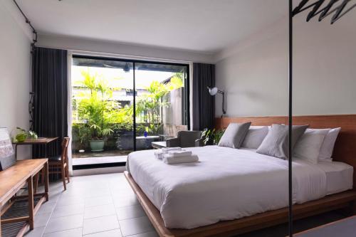 a bedroom with a large bed and a large window at GalileOasis Boutique Hotel in Bangkok