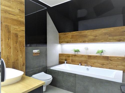 La salle de bains est pourvue d'une baignoire, de toilettes et d'un lavabo. dans l'établissement Góralska Osada Karpacz -Wood House 8 osobowy Dom Lux, à Karpacz
