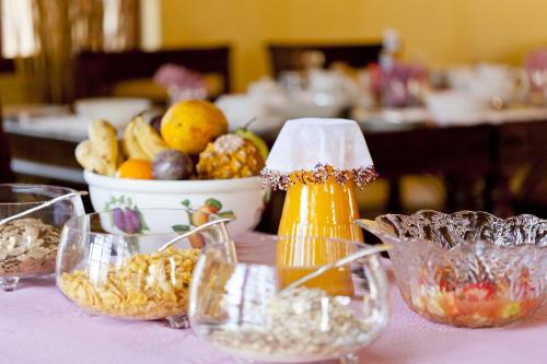 a table topped with bowls of food and a bowl of fruit at Needles Lodge in Marloth Park