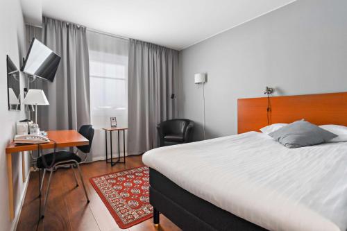 una camera d'albergo con un grande letto e una scrivania di Best Western Hotel Botnia a Umeå