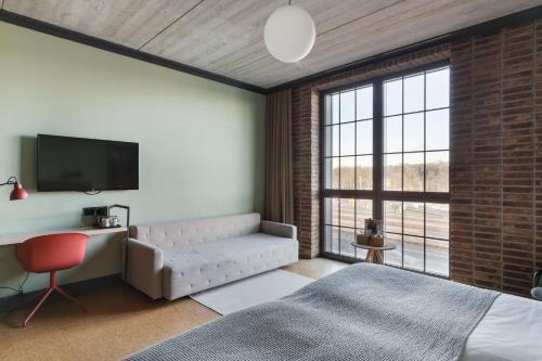 a bedroom with a bed and a large window at The Winery Hotel, WorldHotels Crafted in Solna