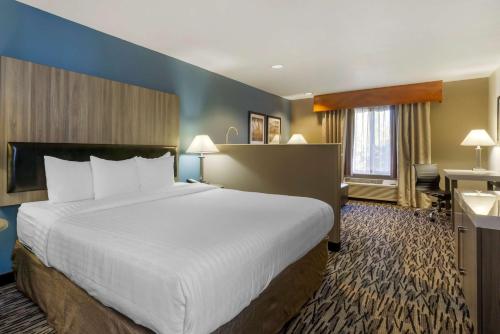 a hotel room with a large bed and a desk at Best Western PLUS Mountain View Auburn Inn in Auburn
