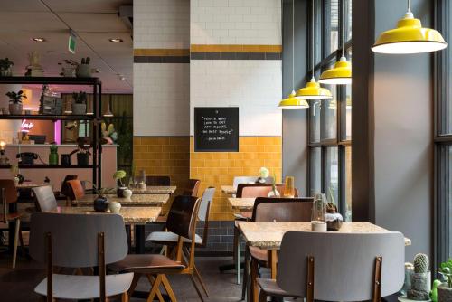ein Restaurant mit Tischen und Stühlen und einer Tafel an der Wand in der Unterkunft Best Western Plus Hotel Noble House in Malmö