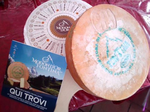 a wooden spoon with a cake on it next to a book at Hotel Les Granges in La Thuile