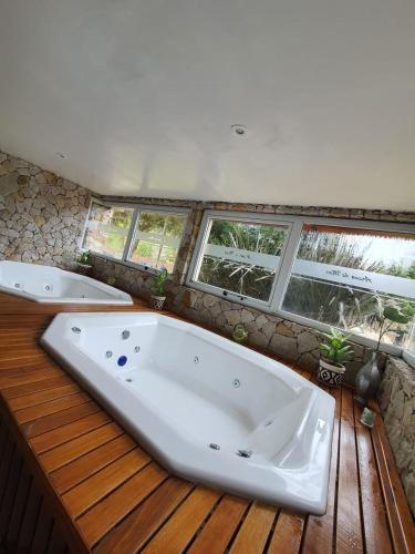 a large bath tub in a bathroom with windows at Arena de Mar Depto F in Mar de las Pampas