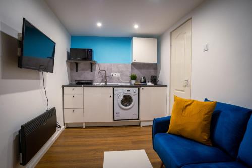 ブダペストにあるCasa Wesselenyi - Cosy Apartments in the city centerの青いソファとキッチンのあるリビングルーム