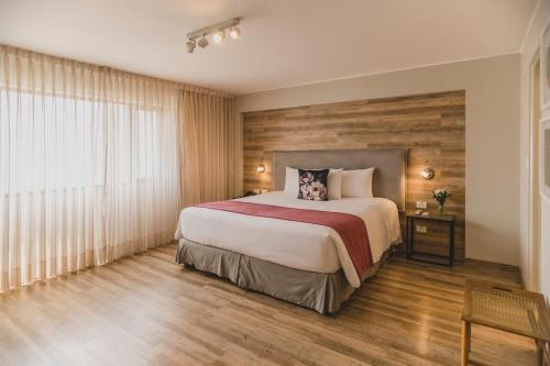 um quarto com uma cama grande e uma parede de madeira em ARTE HOTEL Lima em Lima