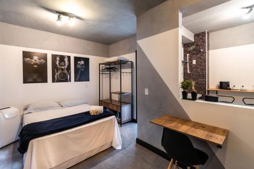 Un dormitorio con una cama y una mesa. en AA - Studio Encantador na Bela Vista, Próximo à Avenida Paulista, en São Paulo
