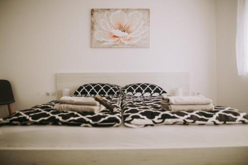 a bed with a black and white blanket and pillows at Kuća za odmor Tamaris in Vukovar