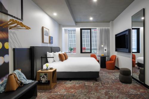 ein Hotelzimmer mit einem Bett und einem TV in der Unterkunft Veriu Queen Victoria Market in Melbourne