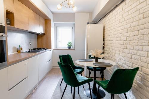 cocina con mesa, sillas y pared de ladrillo en Beautiful and cozy 2 bedroom apartment with living room loft en Cluj-Napoca