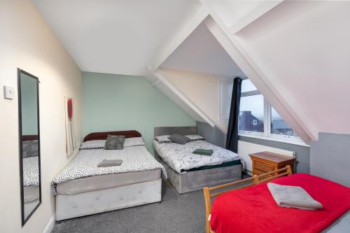 a attic room with two beds and a window at City Centre Large Luxury Rooms Free Parking in Gateshead
